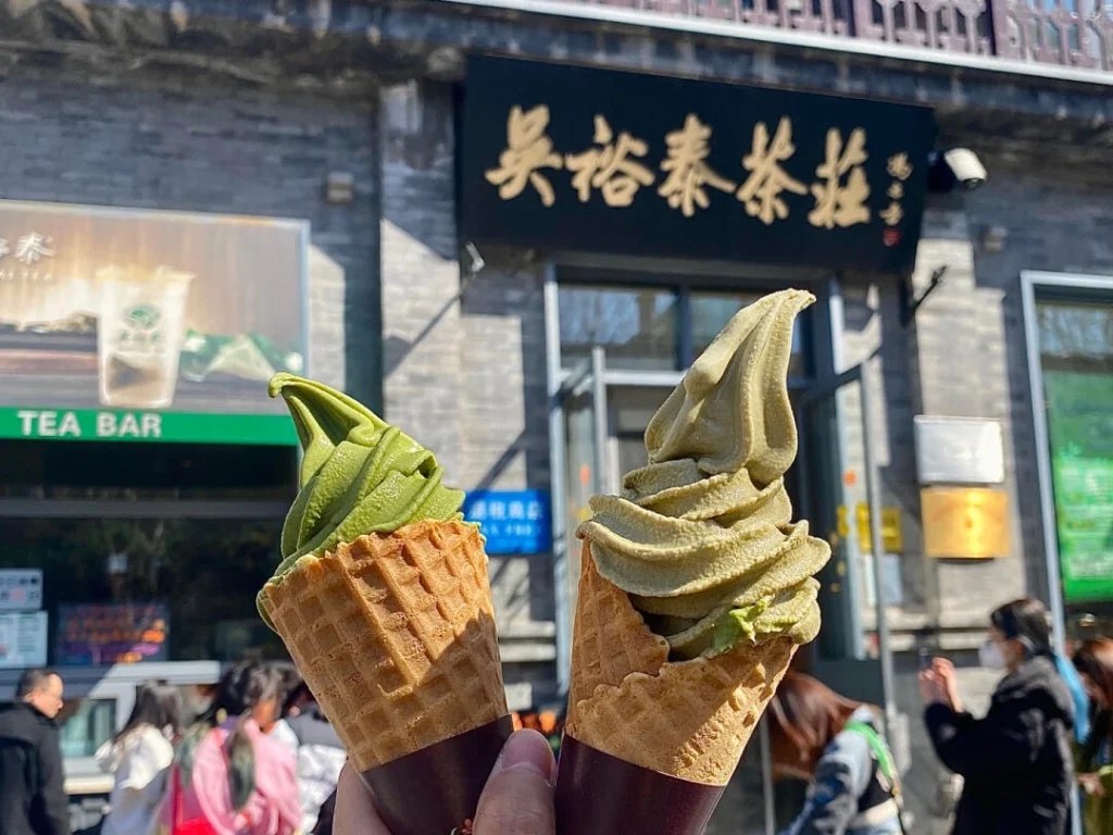 Two tea ice-cream cones in front of a Wuyutai tea shop